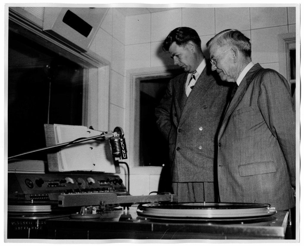 Image of two men in radio studio looking at equipment